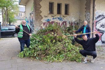 Aktive vom BUND Köln präsentieren einen Haufen mit Grünschnitt am Nikolausplatz.
