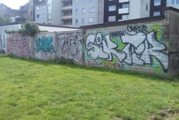 Der Breuerpark wird Richtung Süden von einer Mauer begrenzt.