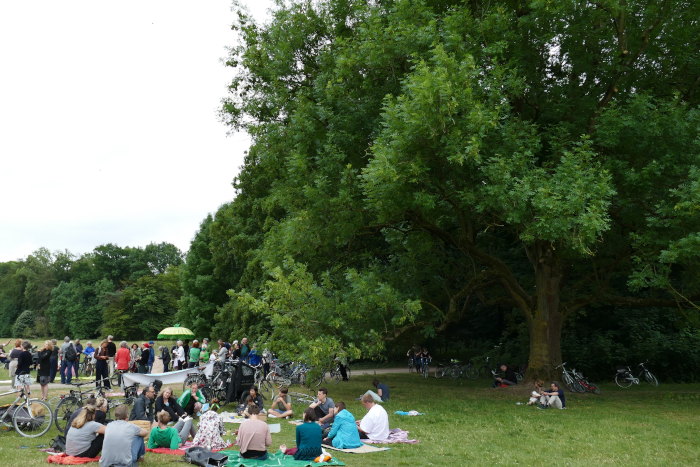 Die Teilnehmer picknicken auf der Gleueler Wiese um zu protestieren.