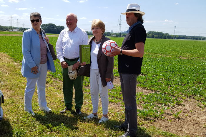 Frau Prof. Barbara Schock-Werner, Dr.Konrad Adenauer, Frau Prof.Dr.Hiltrud Kier, und Roland Schüler stehen vor der Ackerfläche, welche bebaut werden soll.